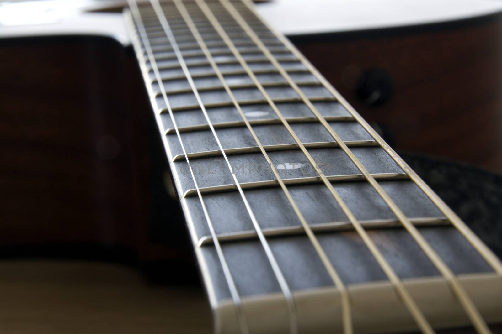 Closeup of an acoustic guitar neck and fret inlay