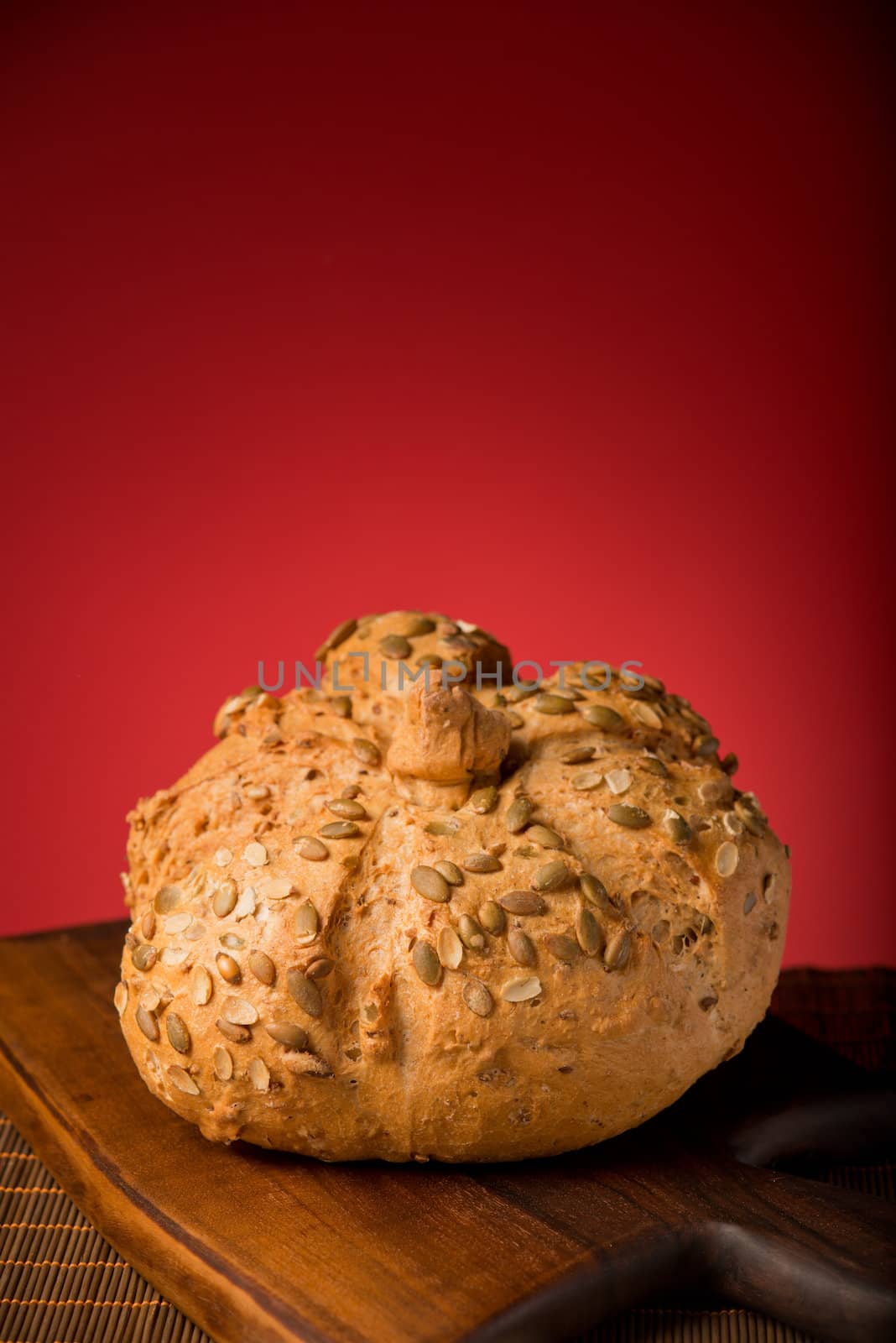 Crusty bun on a wooden board isolated in studio