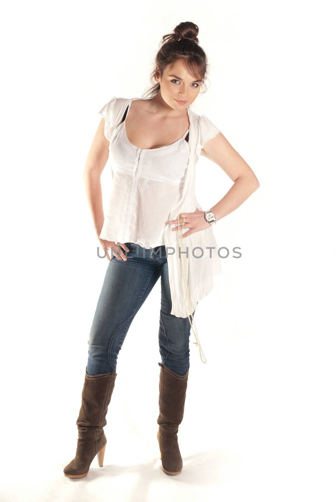 Young brunette posing in studio in jeans isolated on white