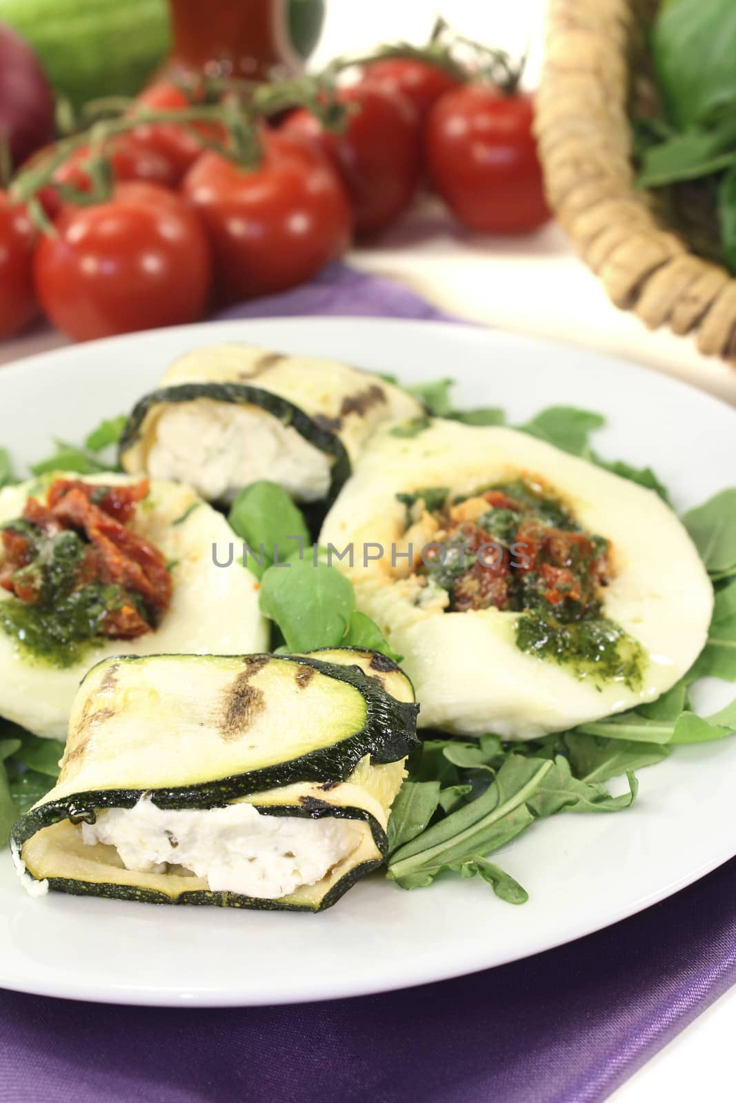 Zucchini rolls and stuffed mozzarella with basil on a light background