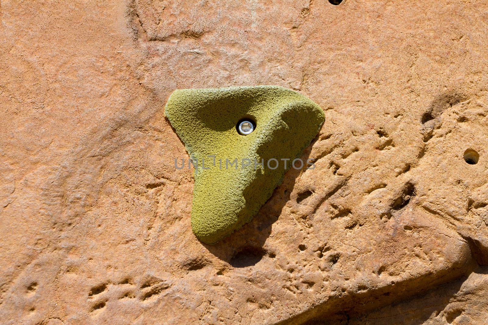 A closeup of a rock climbing wall and the hand holds that are used by climbers to scale the structure.