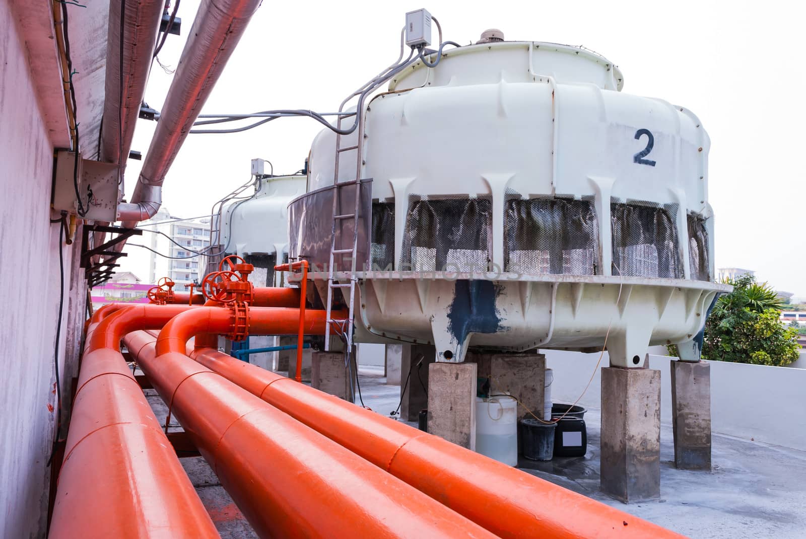 Cooling Tower with Orange Water Pipe on Rooftop.