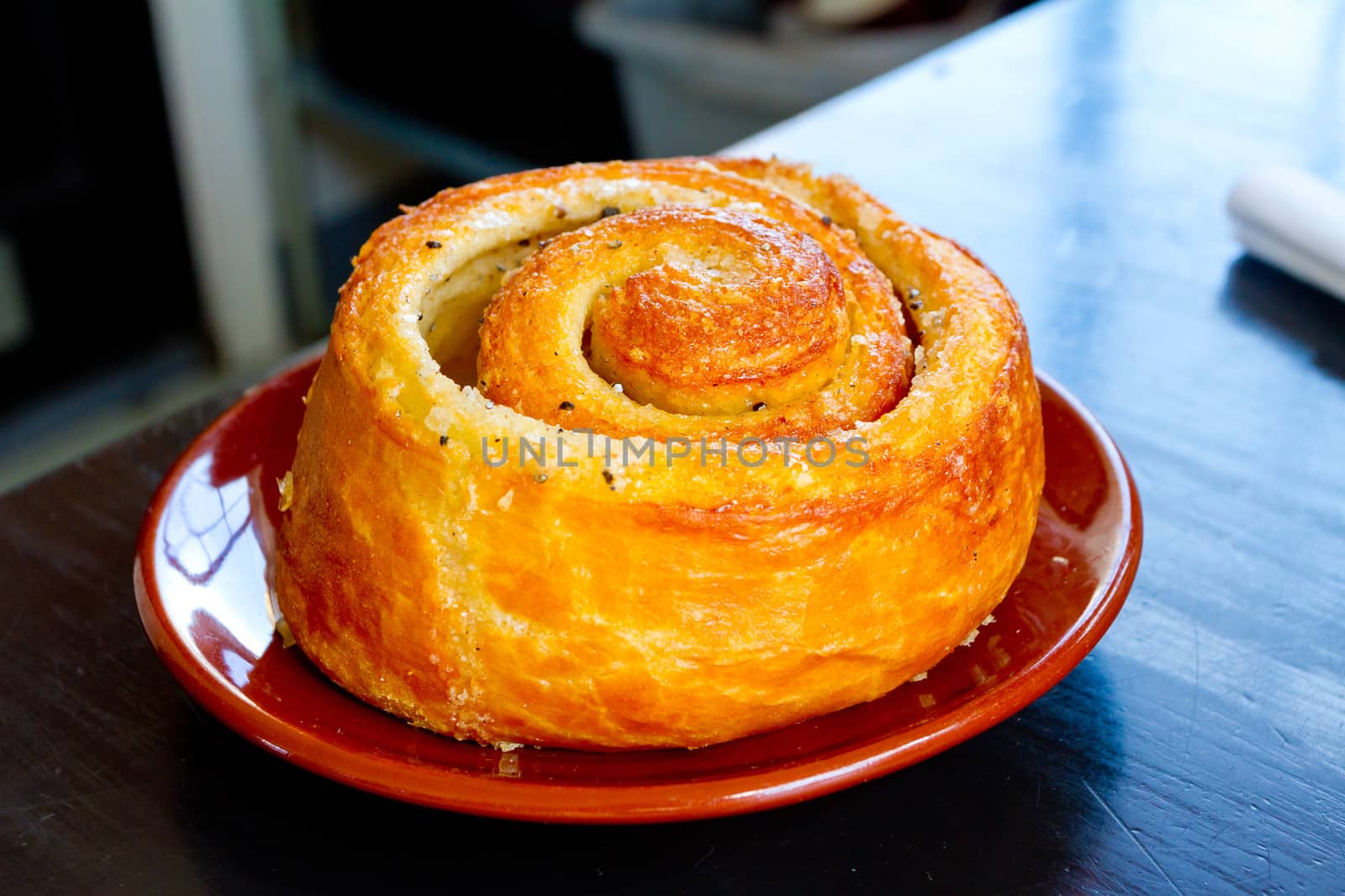 A morning bun cinnamon roll on a plate at a cafe restaurant.