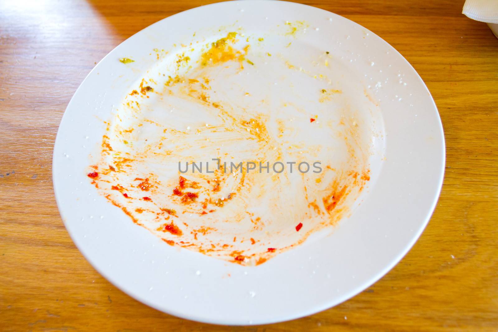 This plate used to have food on it but everything was been eaten at this restaurant leaving the plate where the meal was empty.
