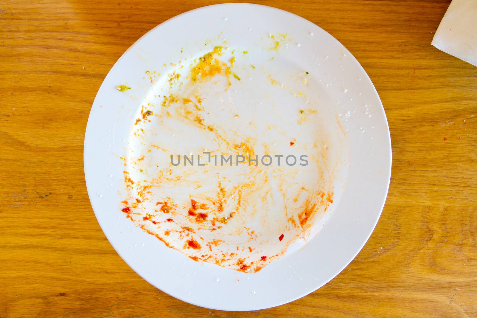 This plate used to have food on it but everything was been eaten at this restaurant leaving the plate where the meal was empty.