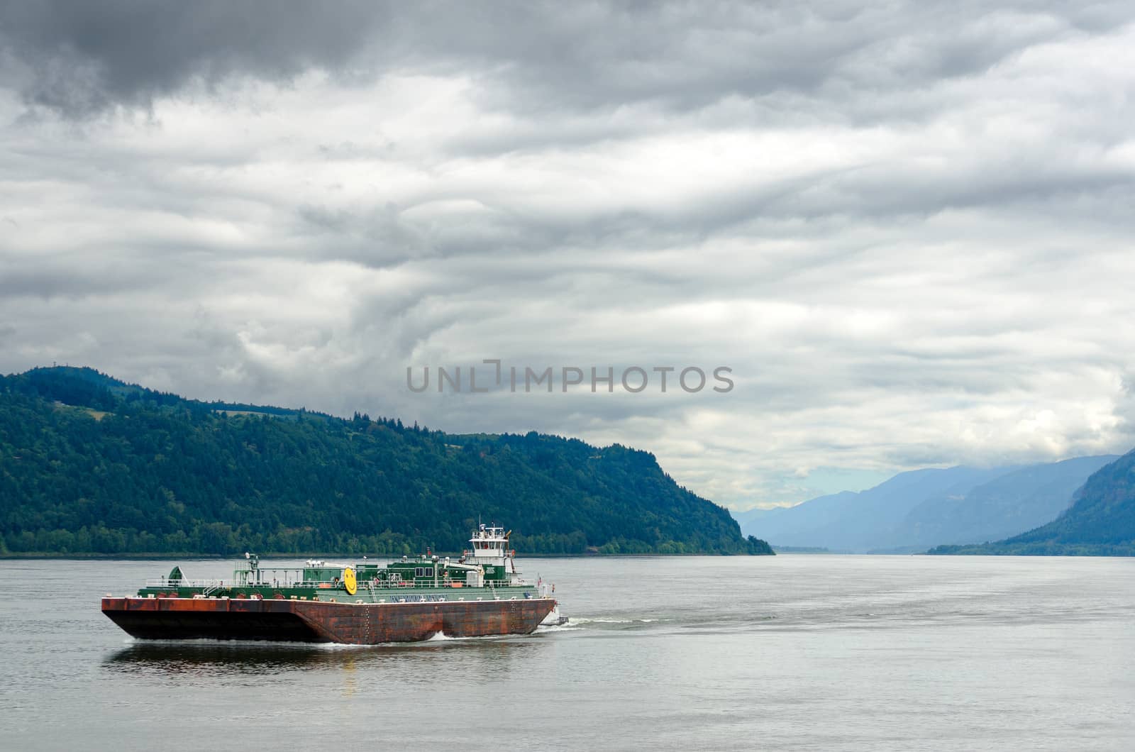 A barge passing through the Columbia River Gorge between Oregon and Washington