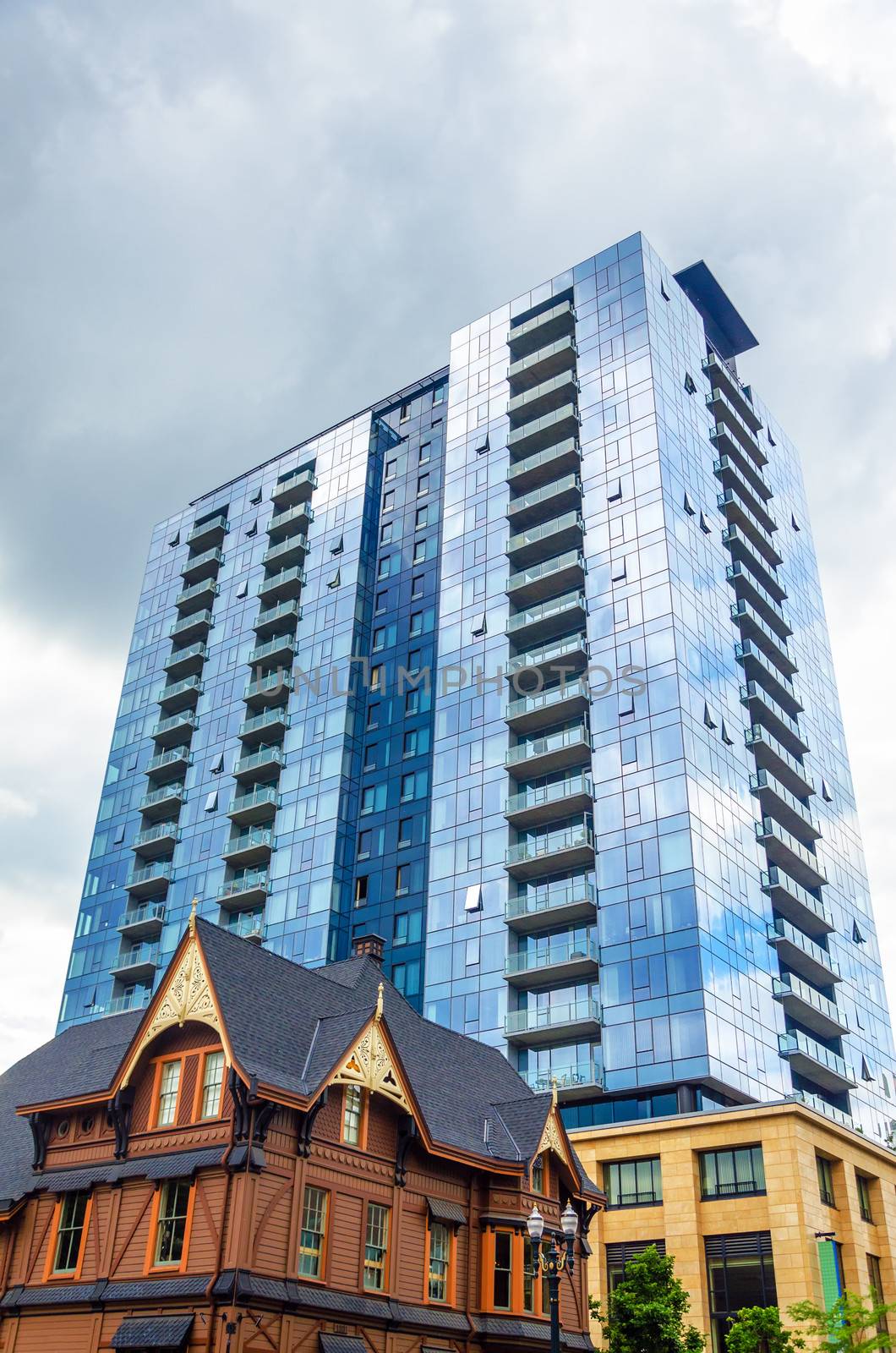 Modern skyscraper rising above a well kept old historic looking house in Portland, Oregon