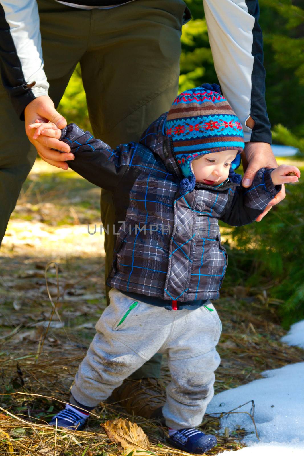 A father and son stop for a moment to share some time playing in the snow on a family hiking adventure.