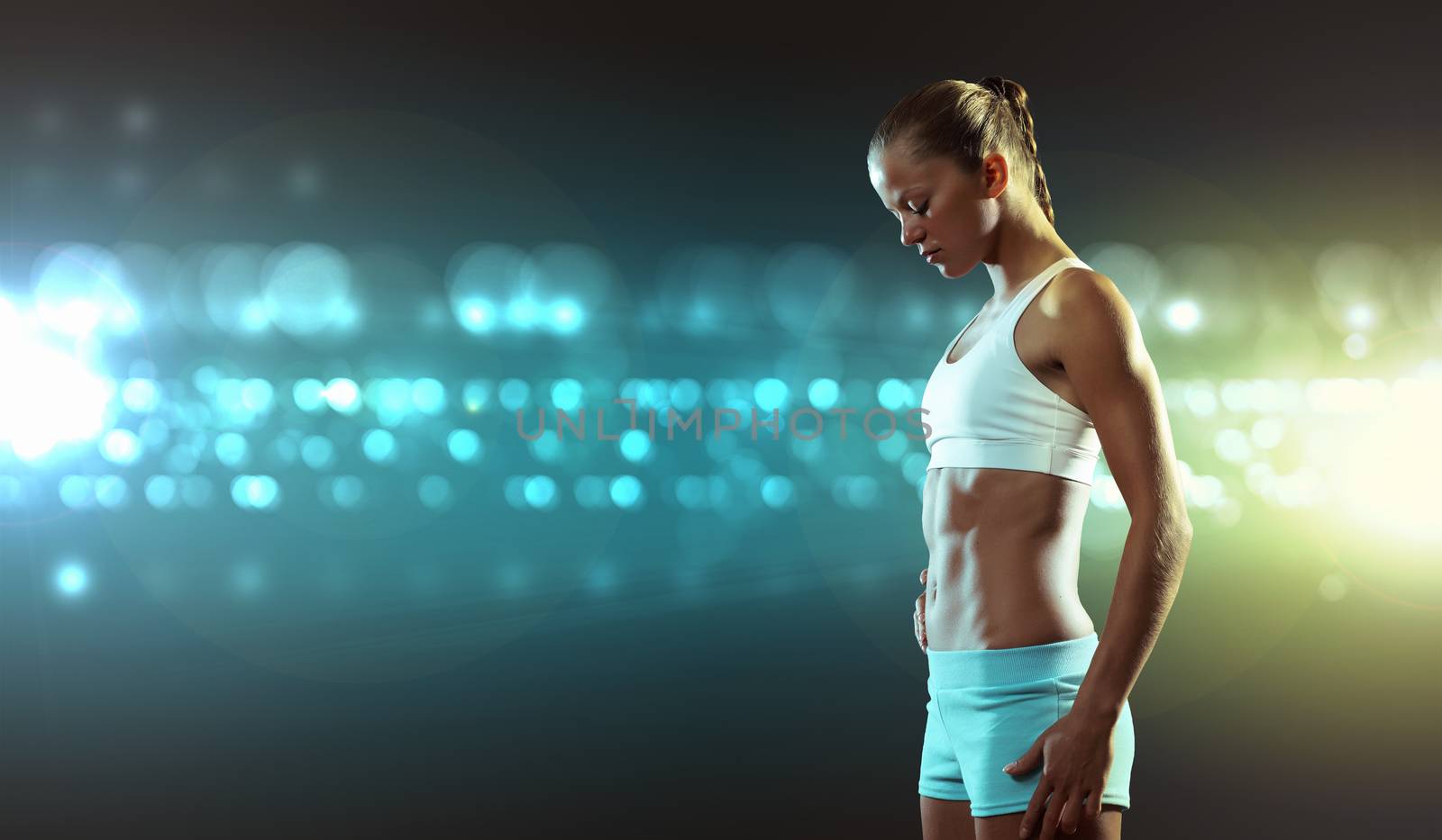 Fitness woman standing against color lights background