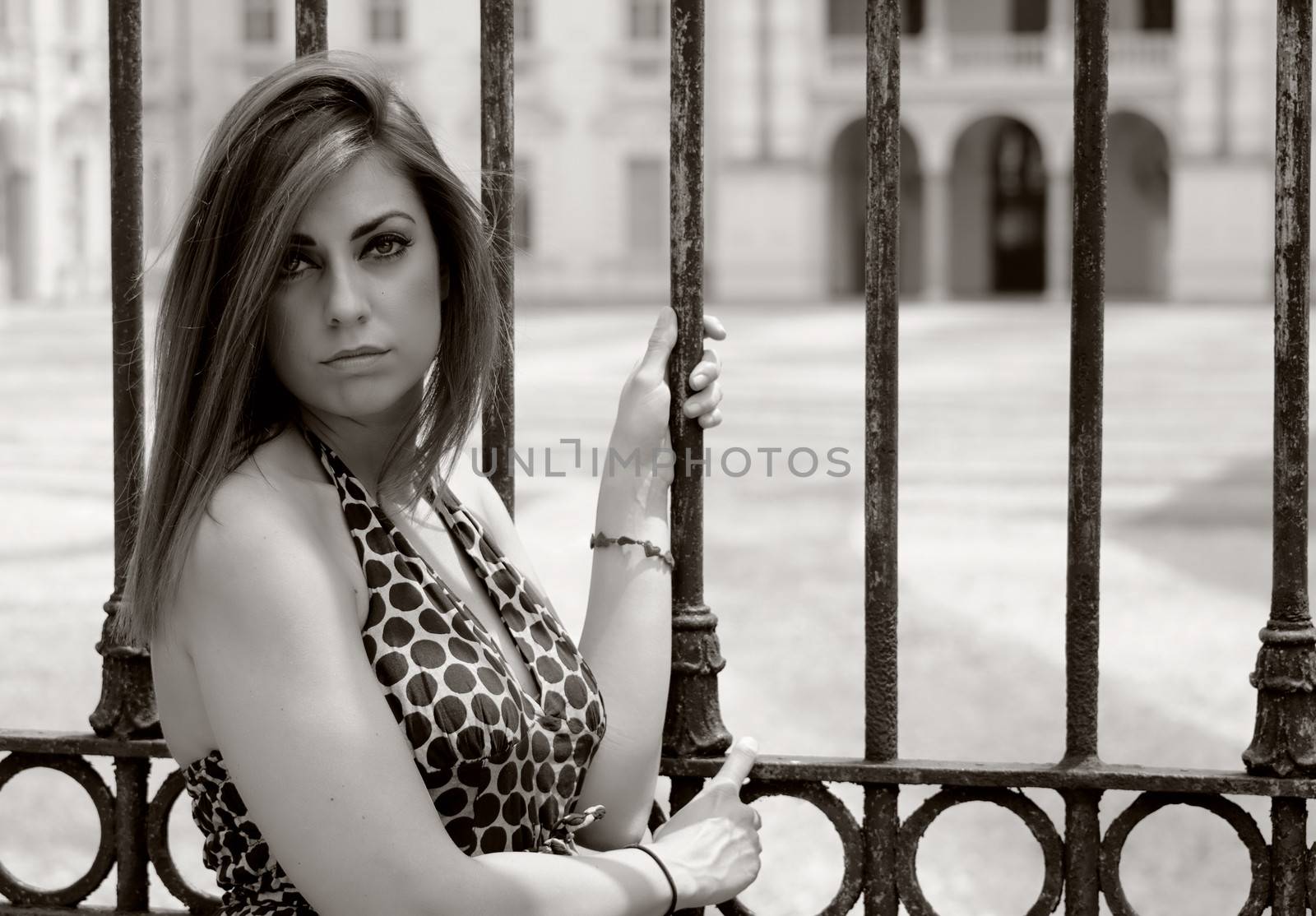 Gorgeous girl in front of old palace entrance gate, sepia colored shot