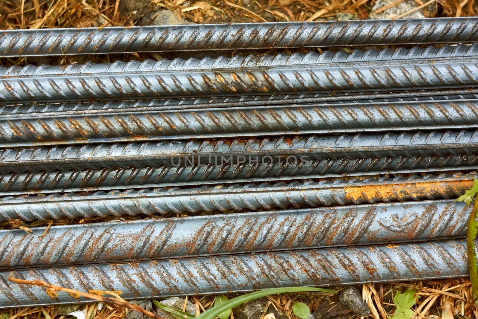 Group of parallel ribbed reinforcement rods lying on the ground