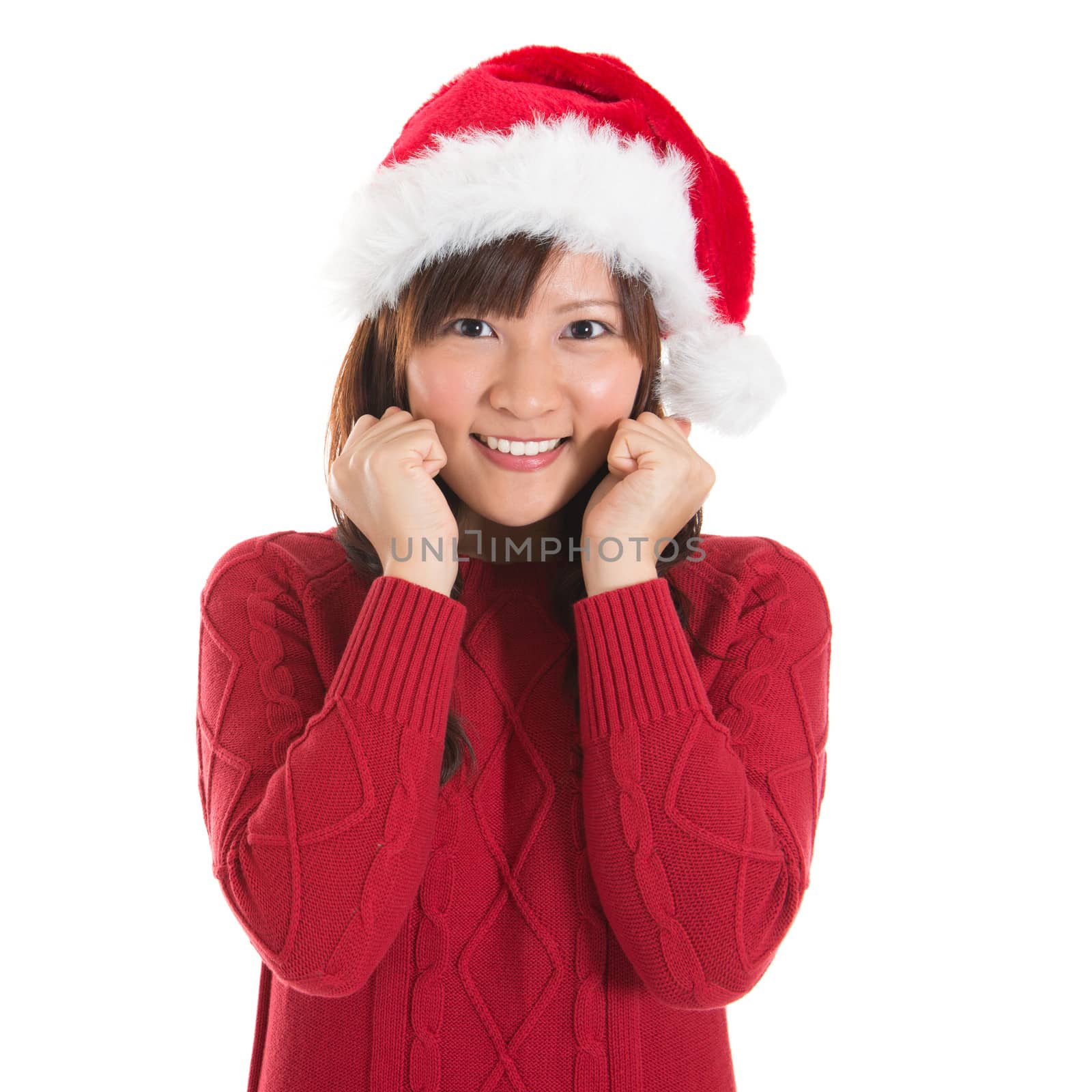 Happy Asian Christmas woman wearing santa hat. Christmas woman portrait of a cute, beautiful smiling Asian Chinese / Japanese model. Isolated on white background.