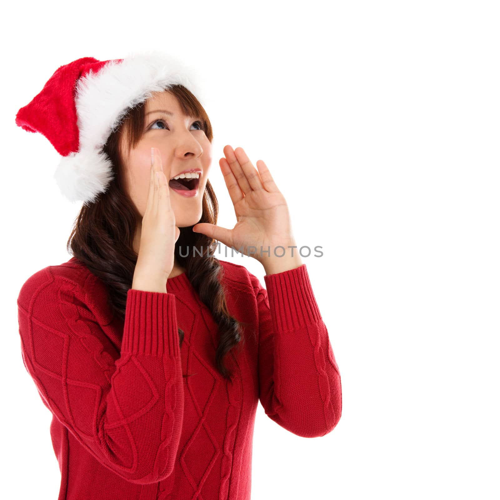Happy Christmas woman shouting excited isolated on white background wearing red Santa hat. Beautiful Asian model.