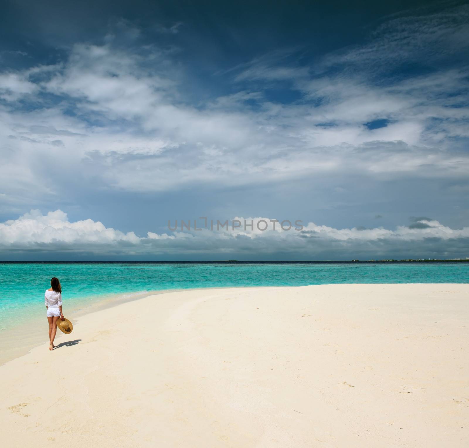 Woman in sun hat at tropical beach