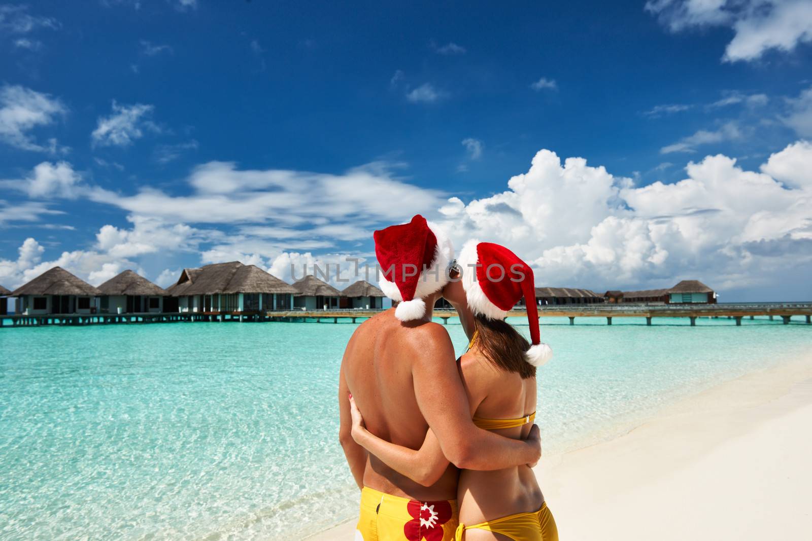 Couple in santa's hat on a tropical beach at Maldives