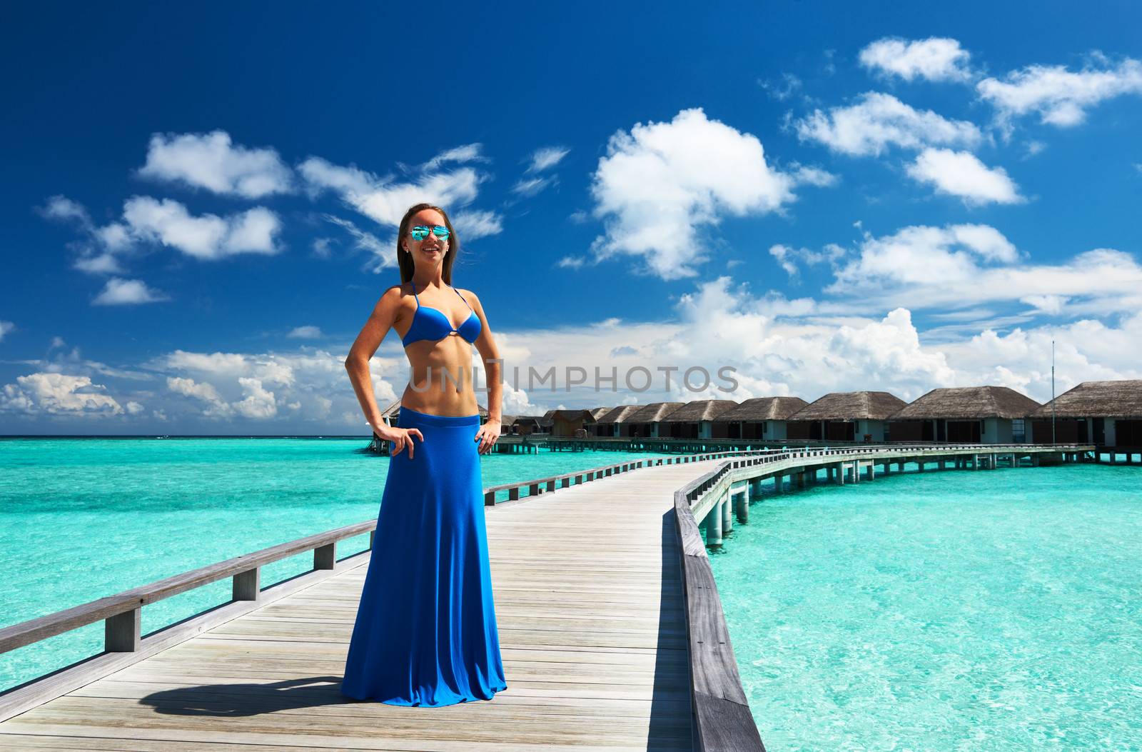 Woman on a tropical beach jetty at Maldives