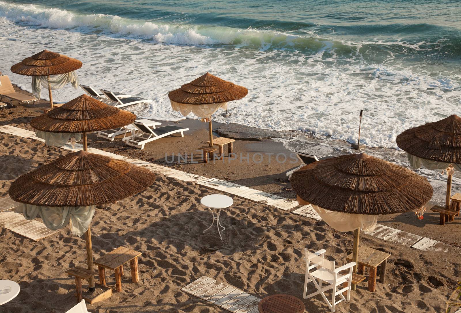 Beach with wooden umbrellas, Crete, Greece 