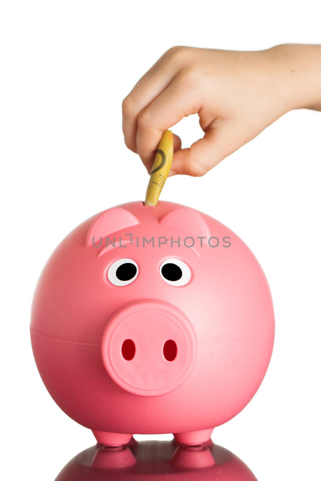 A pink piggybank with Australian dollars in it. Isolated on white.