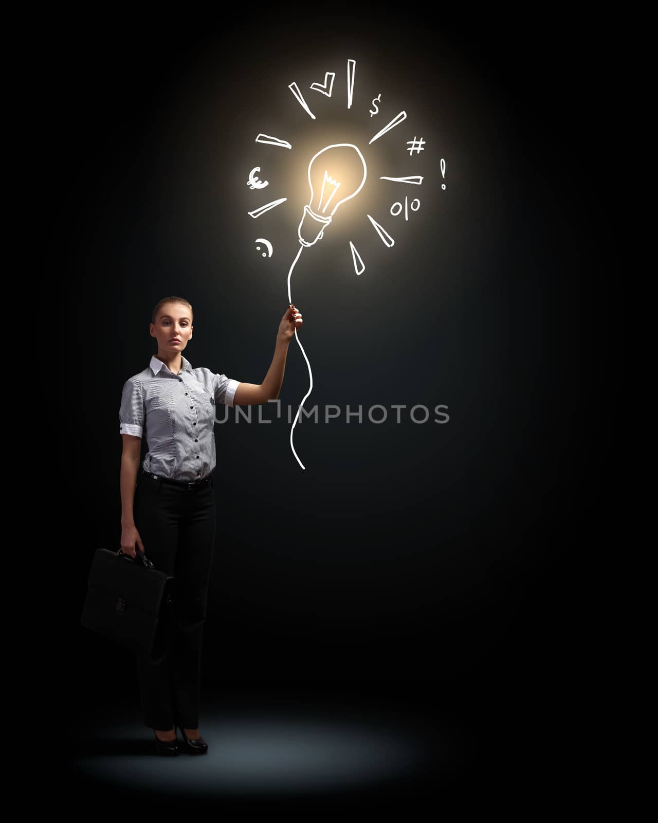 Image of attractive businesswoman against dark background and bulb