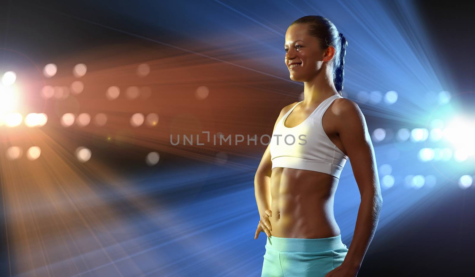 Fitness woman standing against color lights background