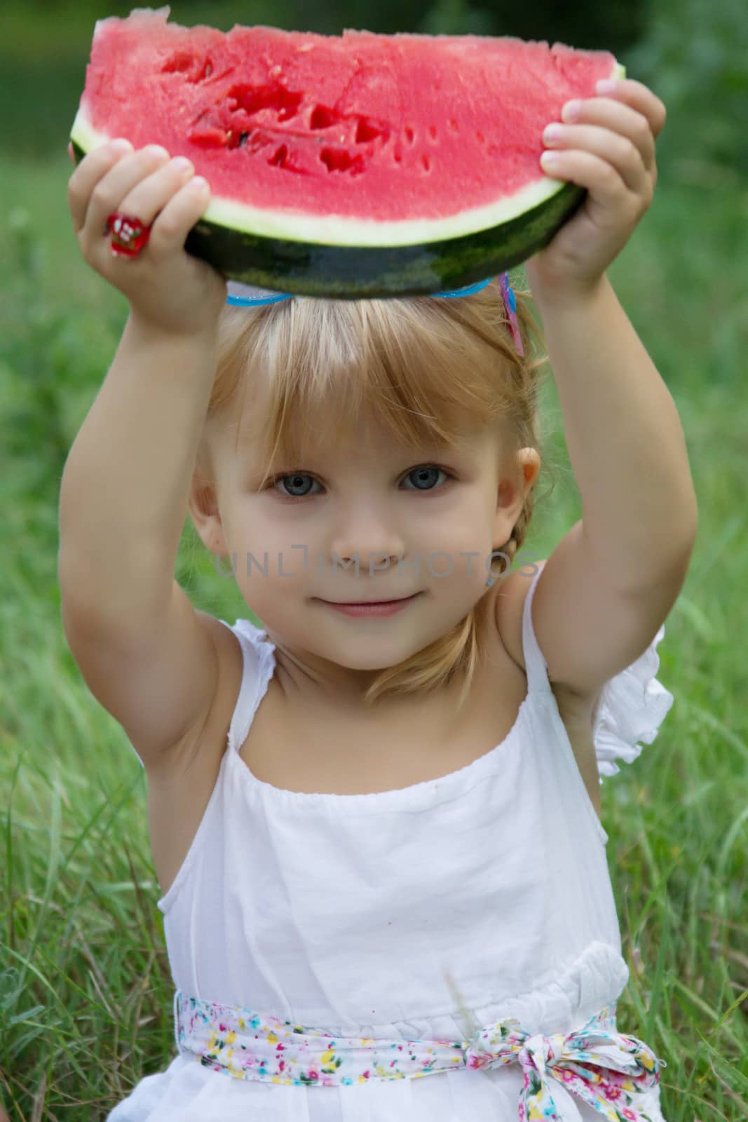 Little girl holding slice of watermelon outdoors by Angel_a