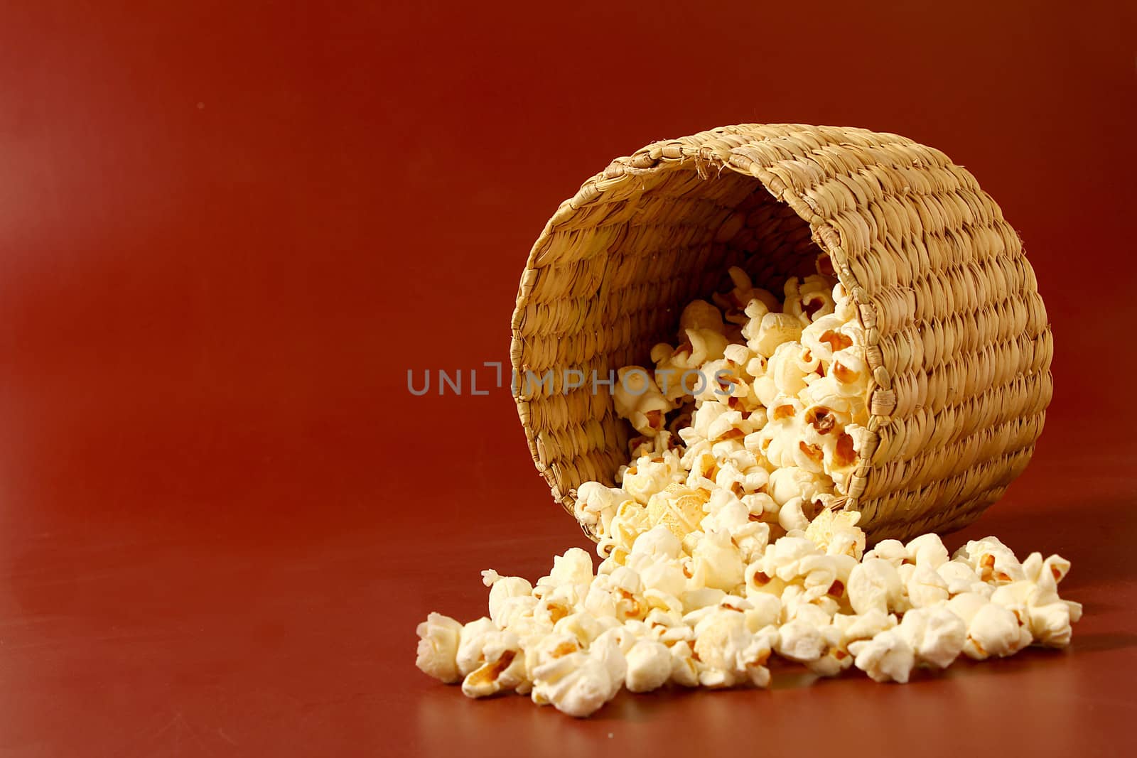 spread popcorn on red background with basket
