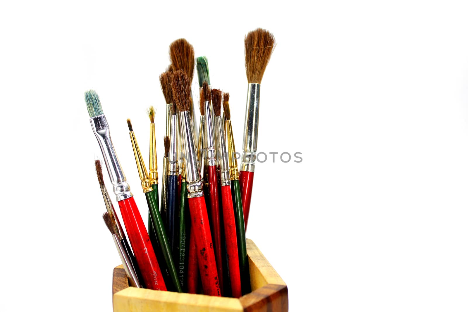 paint brushes in wooden stand isolated white background