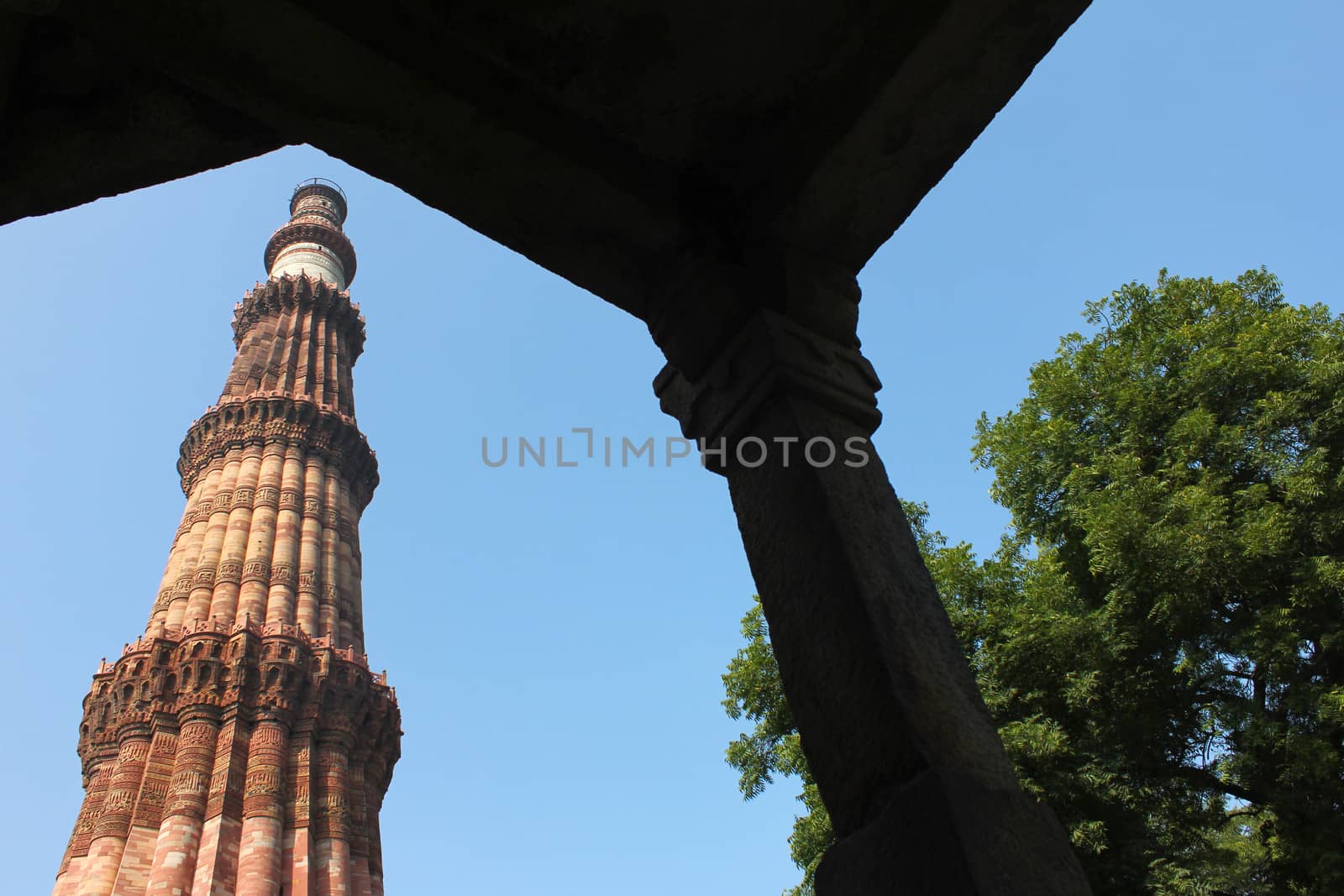 looking through gate qutub minar in blue sky