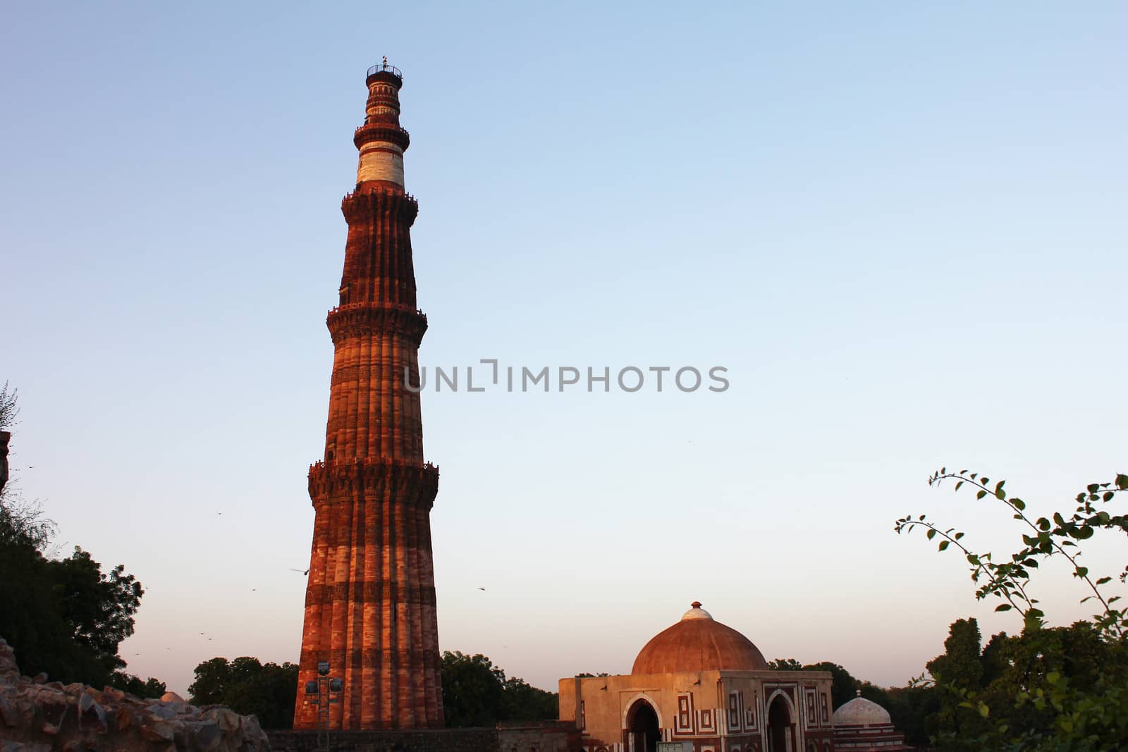 qutub minar with surrounding walls and tombs