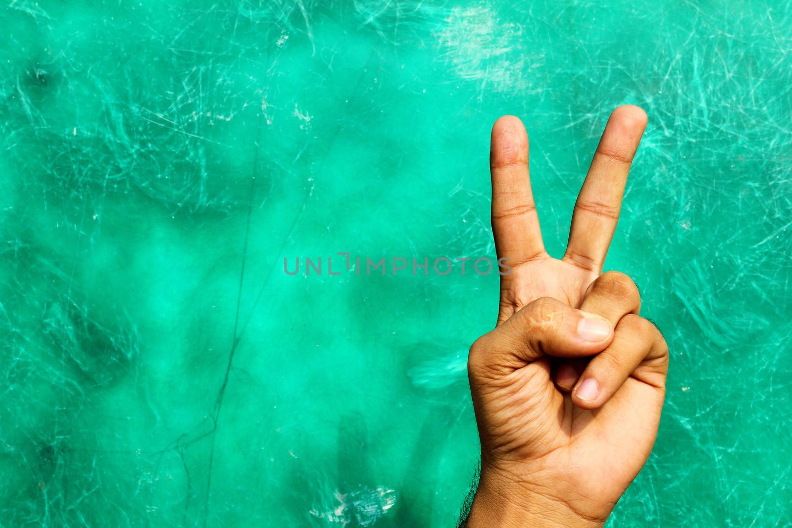 victory sign at grunge green background