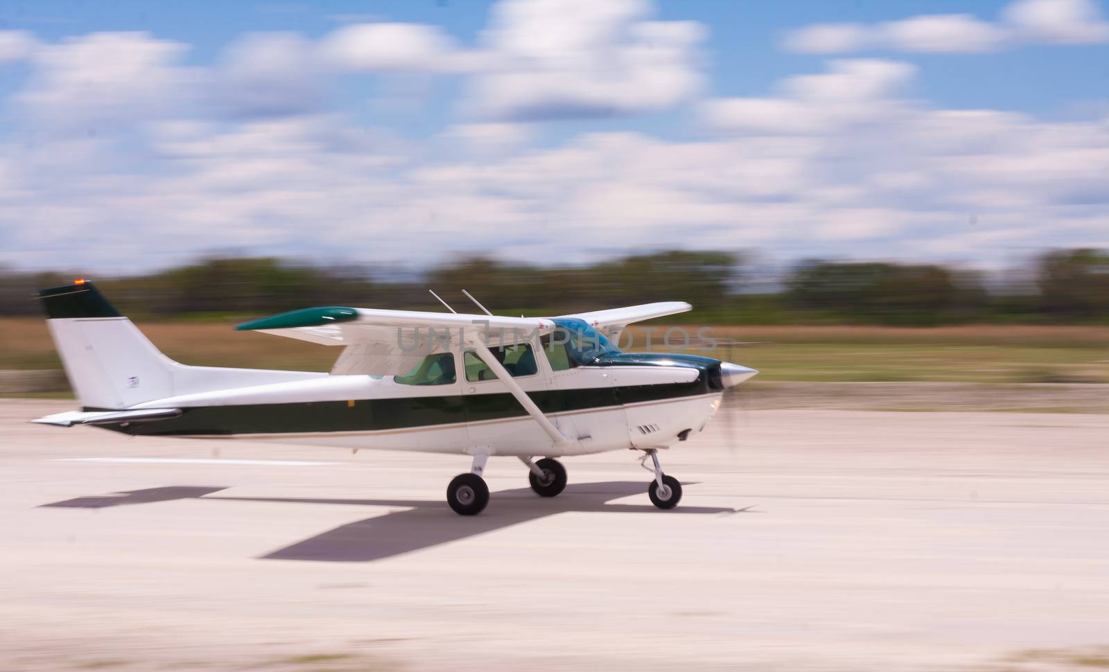 Small airplane landing on a gravel air strip with motion blur to convey movement