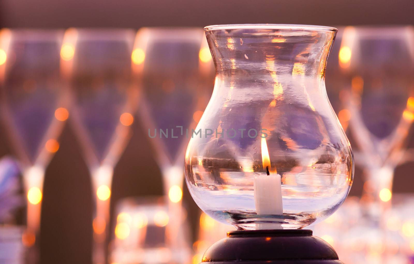 Romantic candle with wine glasss in the background