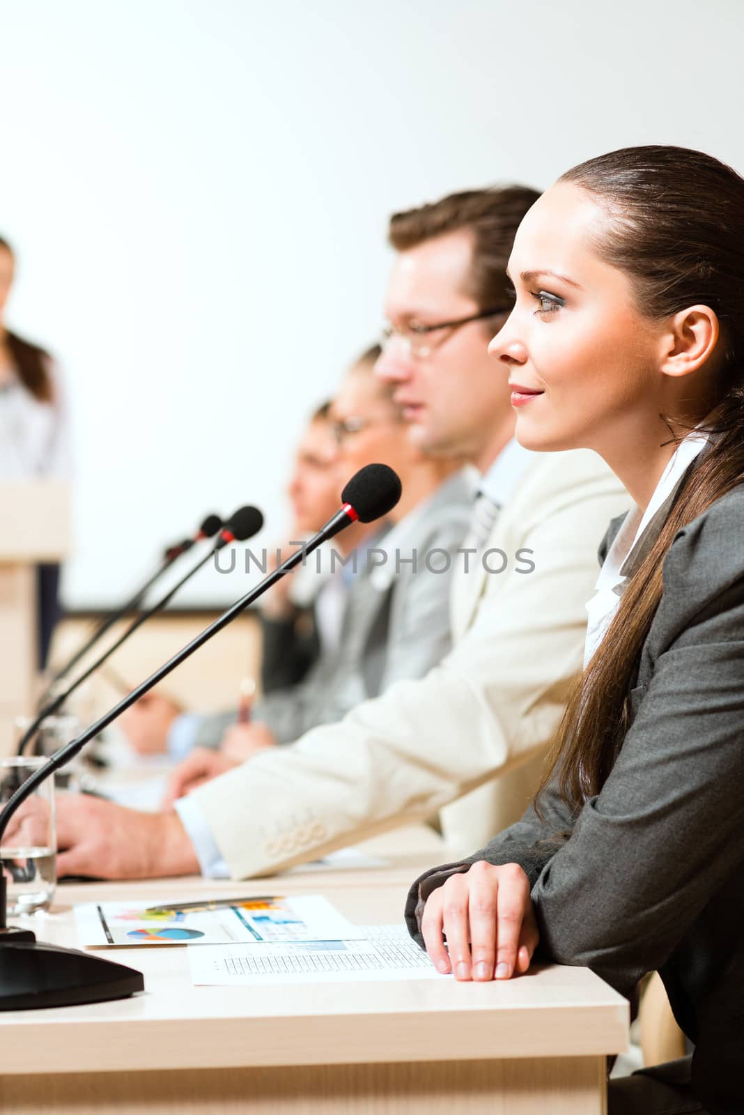 businessmen communicate at the conference, sitting at the table, on the table microphones and documents