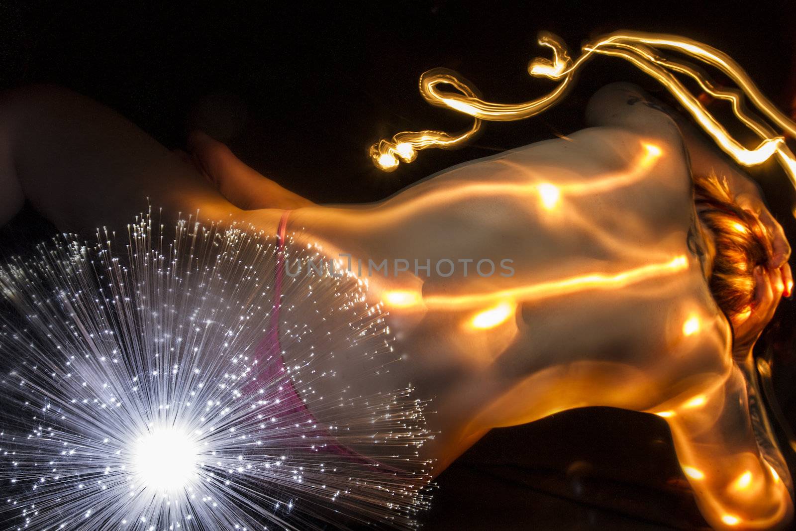 Nude blond woman with fiber optics and light effects on her skin