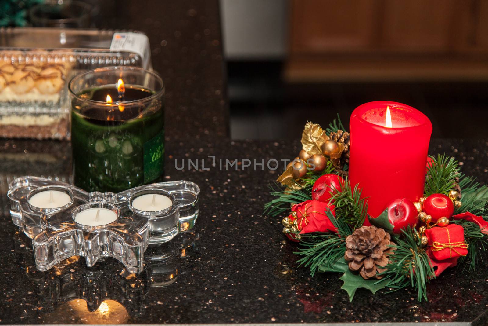 Christmas candle with ornaments on a table.