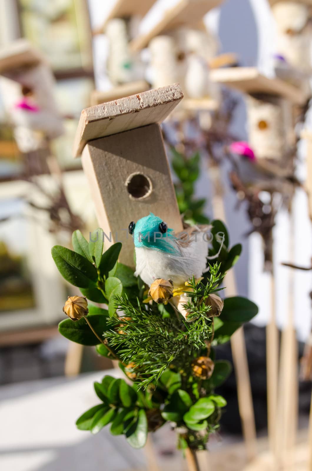 small decoration wooden bird house box and little colorful handmade bird shape figure sold in outdoor spring easter fair market.