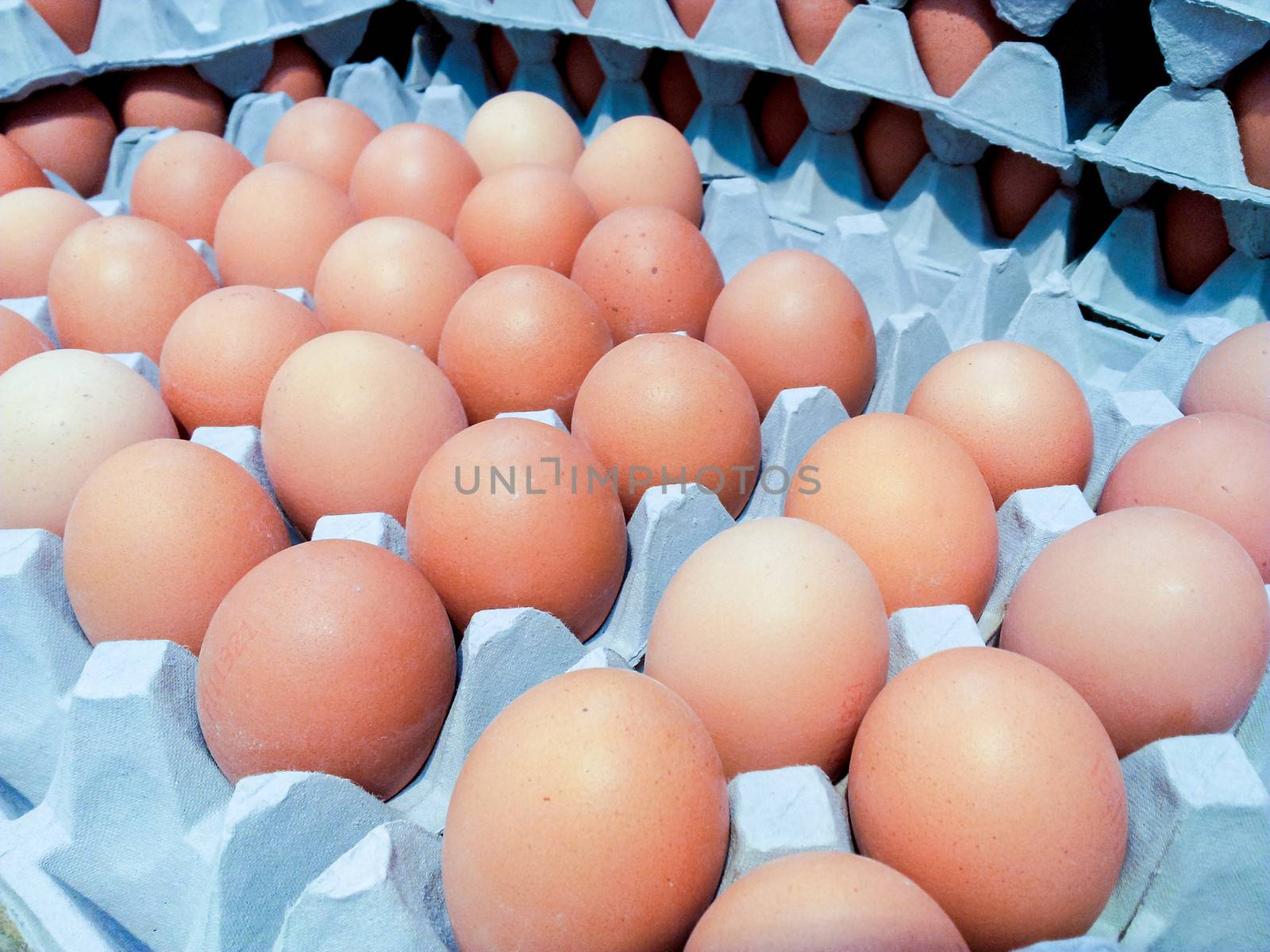 Closeup of brown eggs in grey cardboard boxes at marketplace