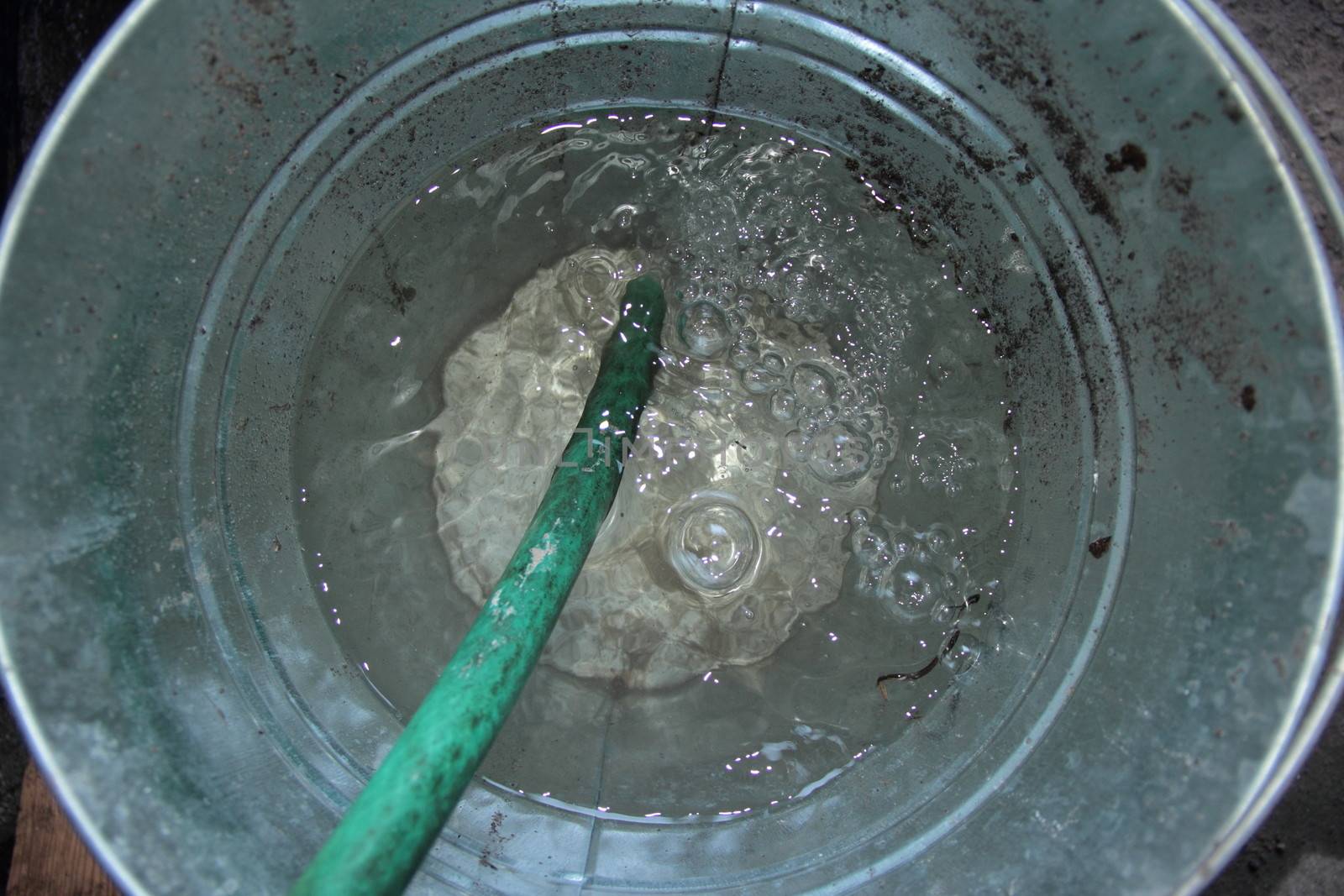 bucket with hose on water
