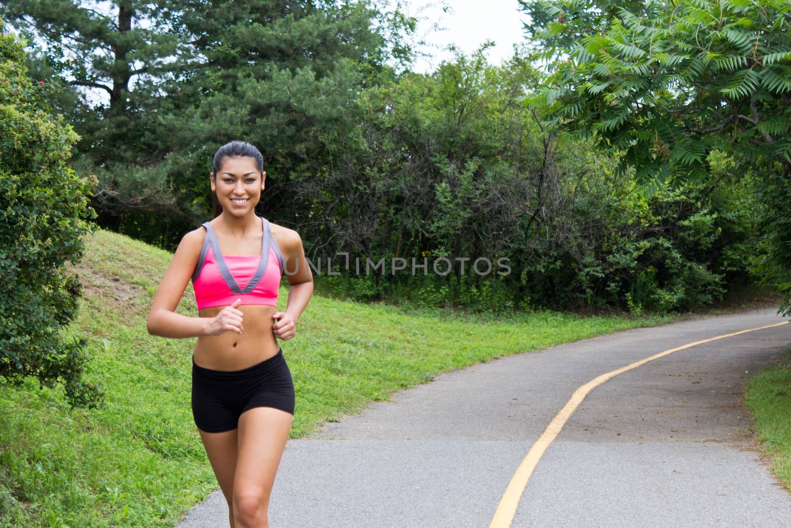 Smiling young woman running for fitness