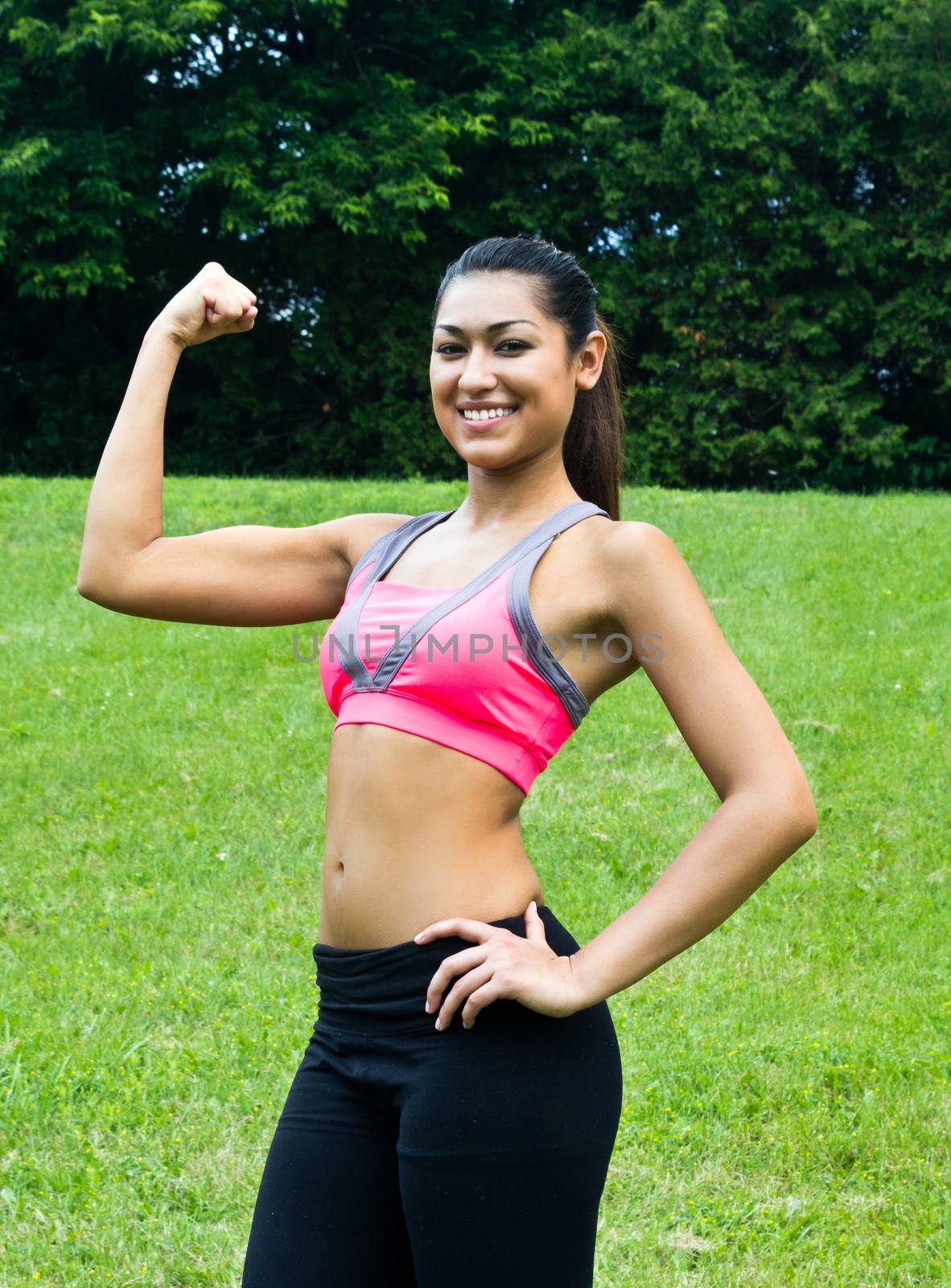 Young fit woman flexes her muscles