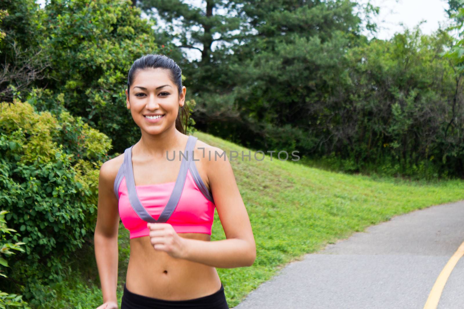 Smiling young woman running for fitness