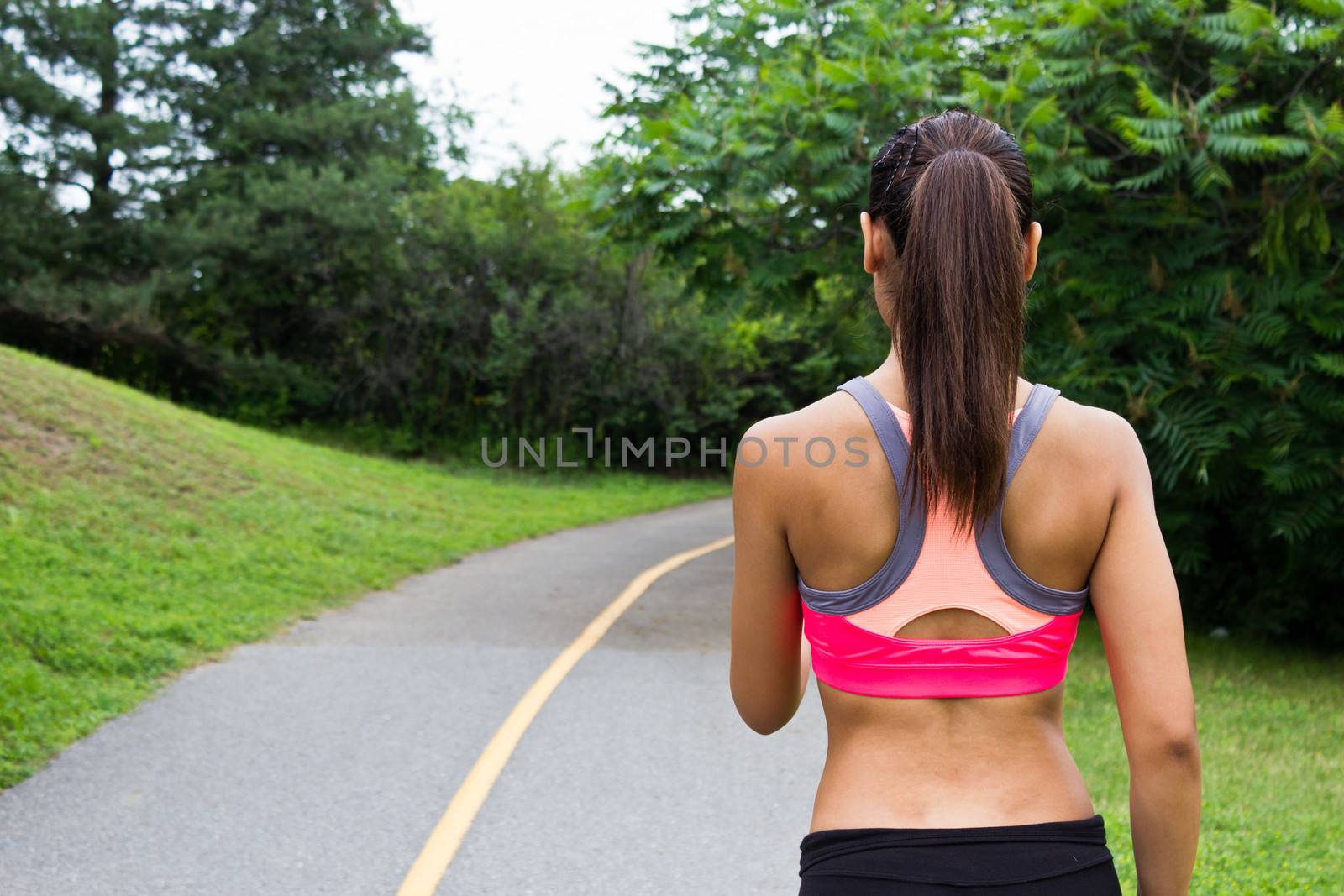 Young woman running on the jogging trail