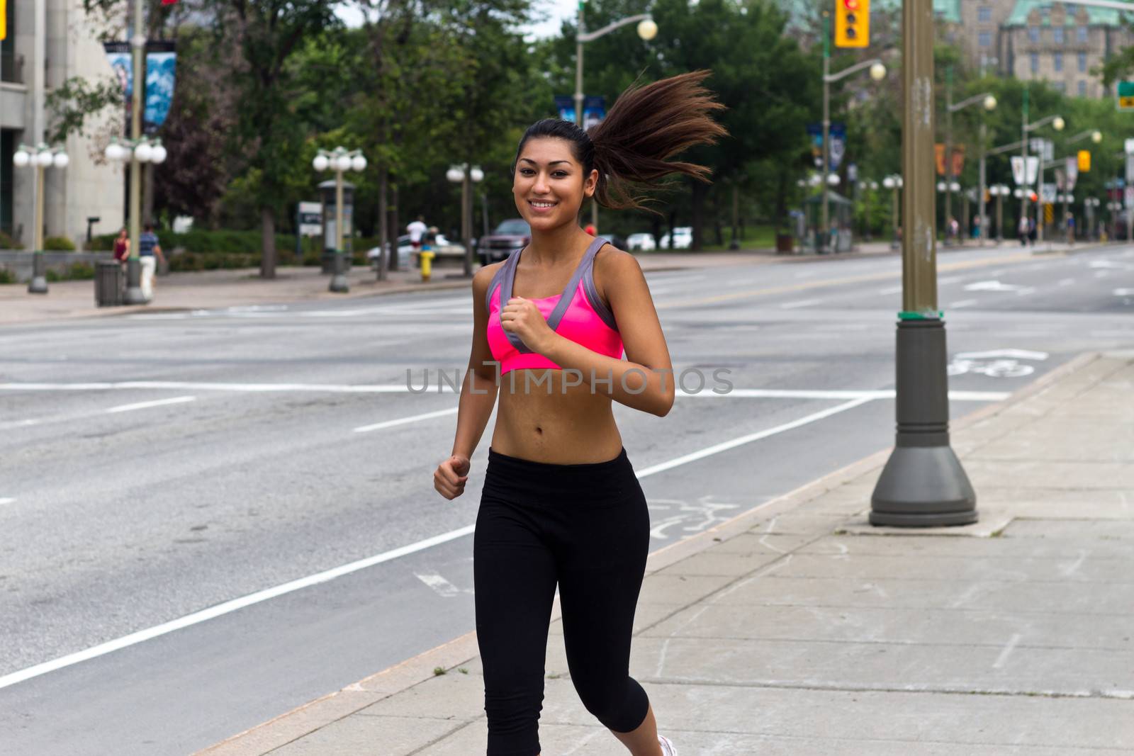 Fit young woman running on a busy city street