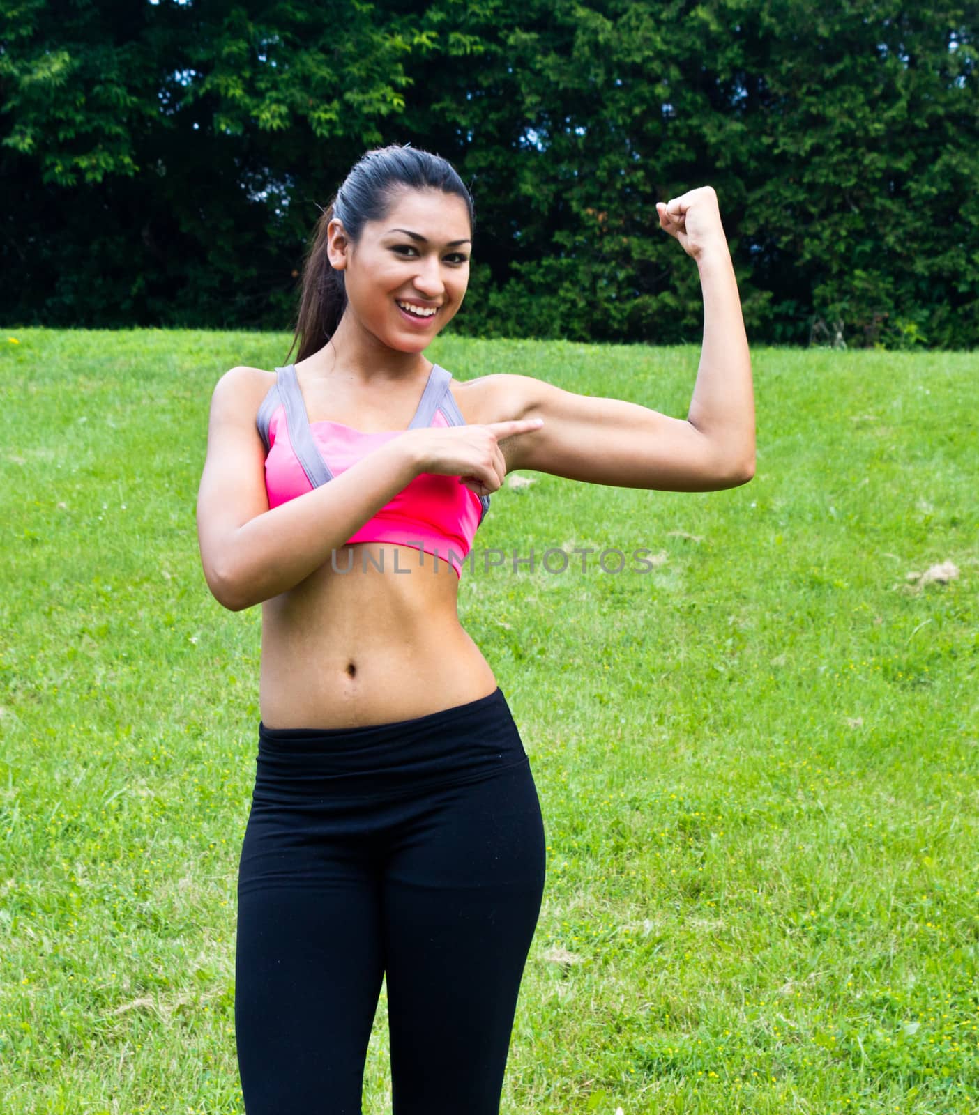 Young fit woman flexes her muscles