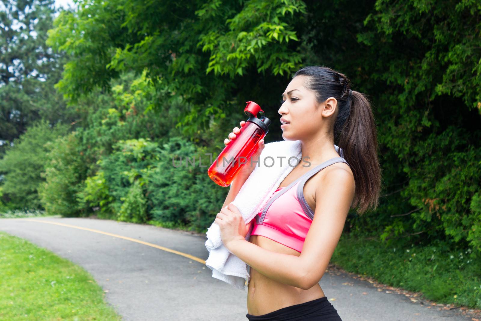 Woman drinks water and rests after running