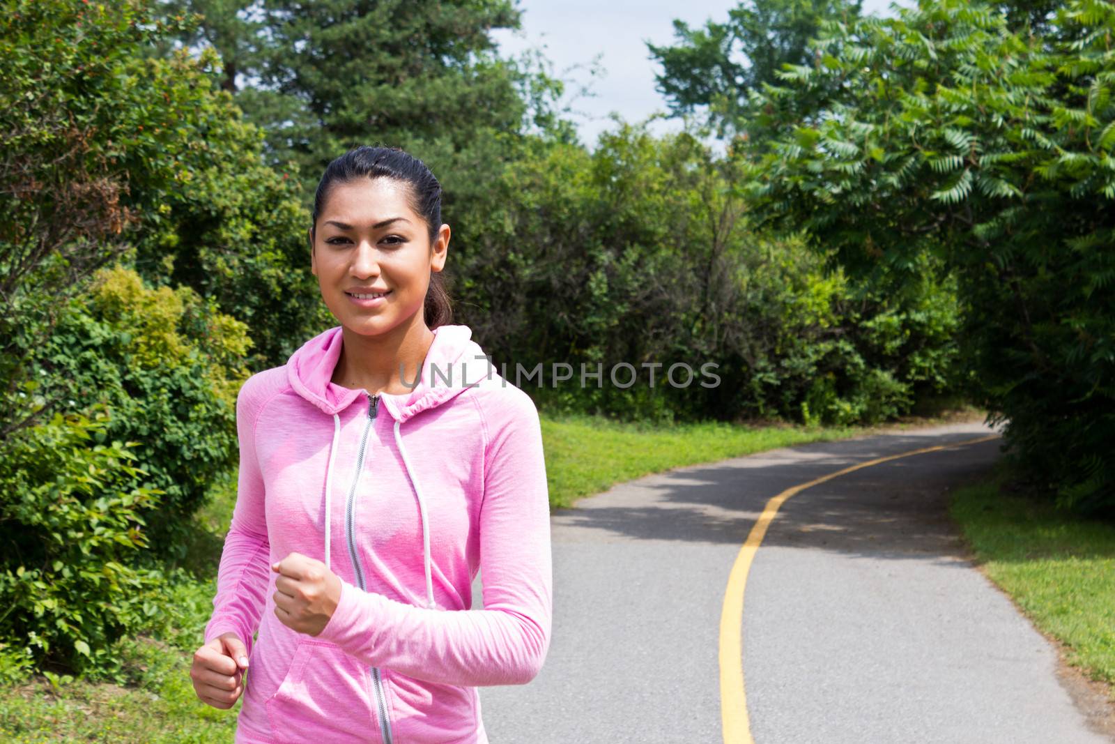 Young, atractive woman running on the nature trail