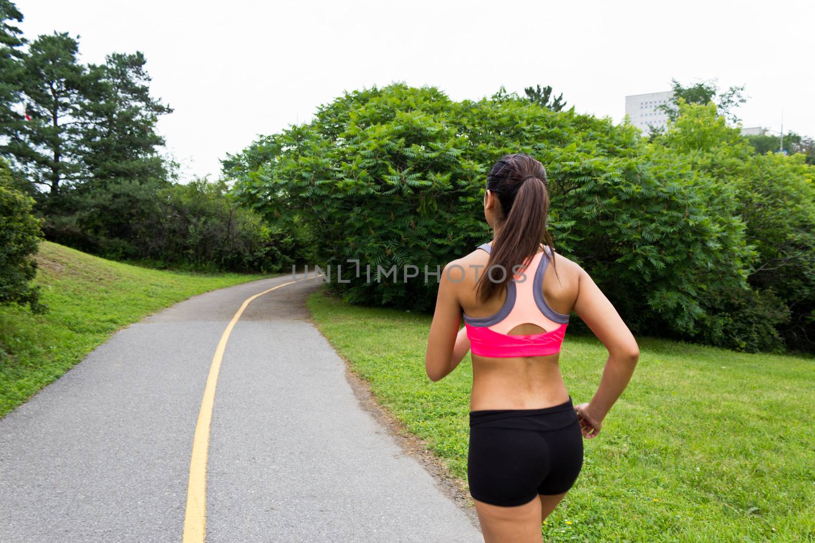 Young woman running on the jogging trail