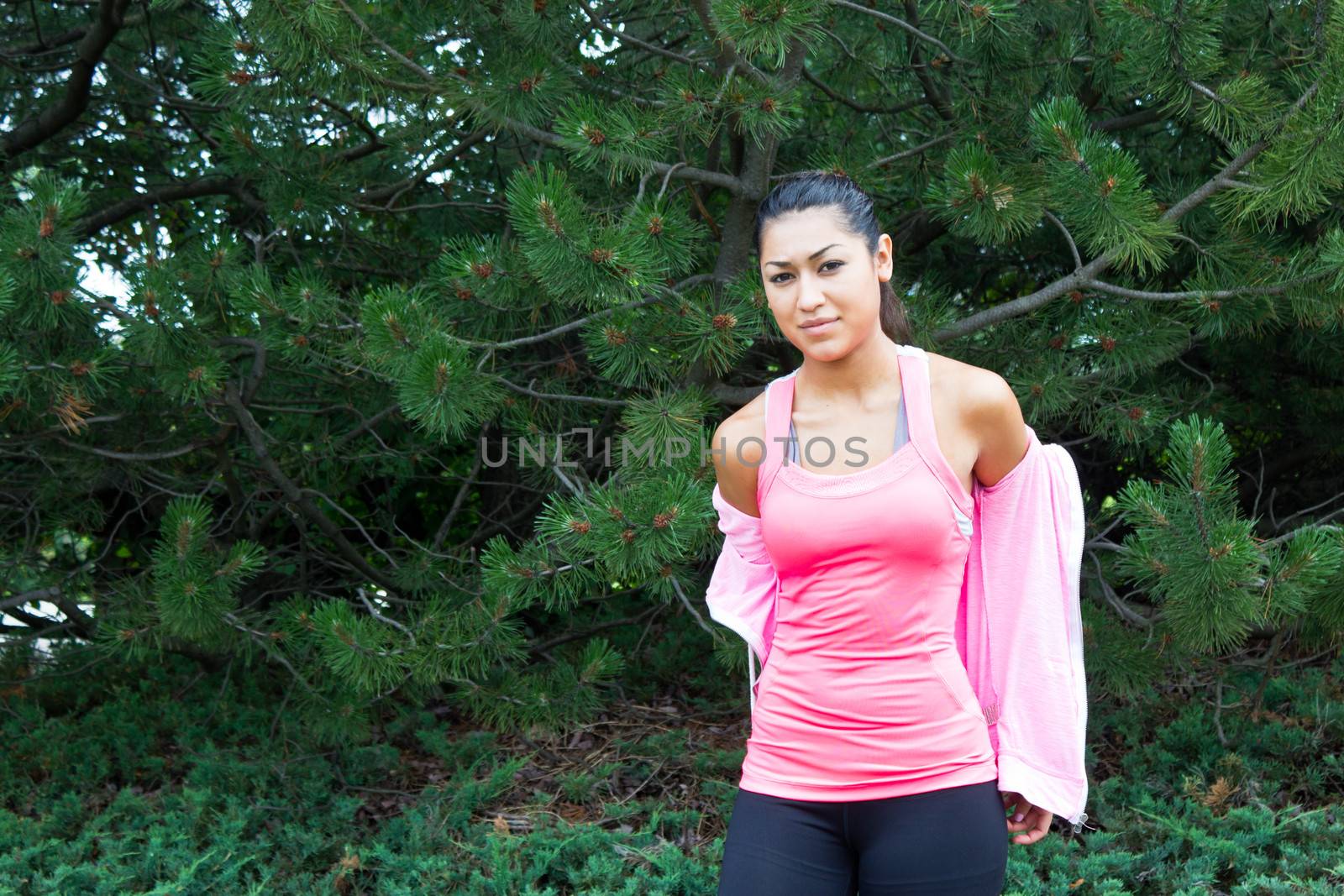 Young woman removing her jacket before a workout