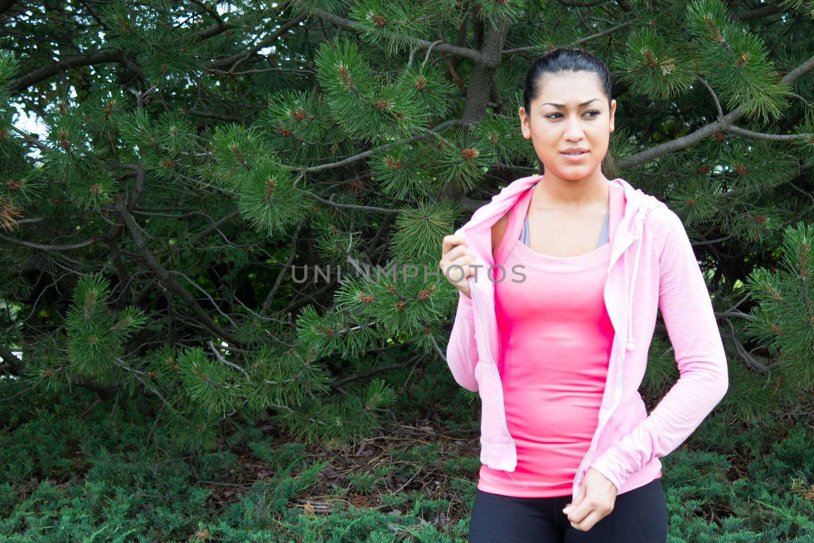 Young woman removing her jacket before a workout