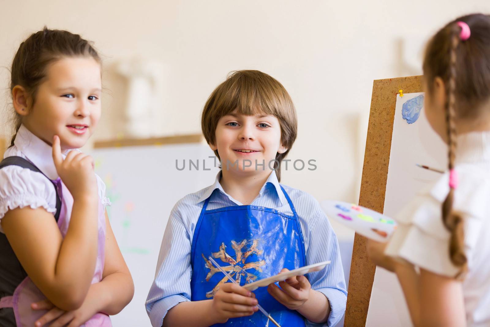 Little children painting and playing at kindergarten